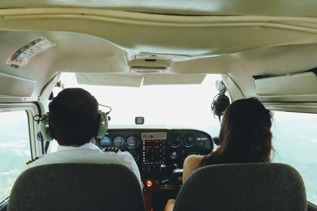Two pilots in a cockpit navigating through the skies over Blumenau, Brazil, providing a unique aviation perspective.